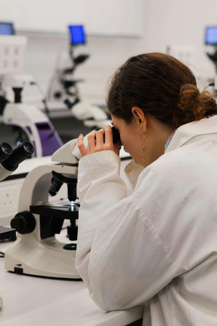 Analista observando amostra no microscópio